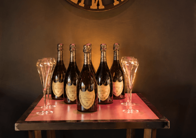 Cinq bouteilles de Dom Pérignon et des flûtes, présentées en salle