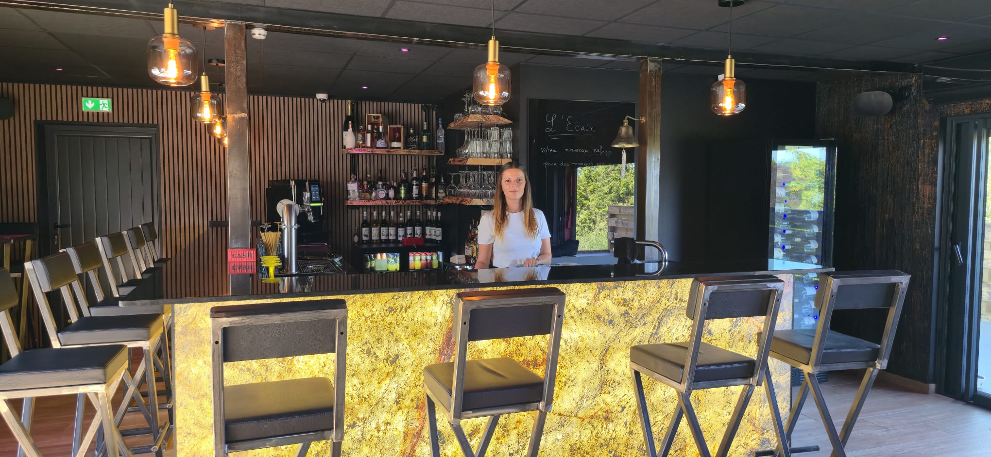 Laura, fondatrice de L'Écrin, derrière le comptoir